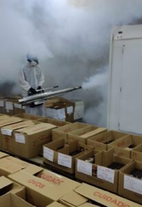 Aplicador realizando fumigação de ambiente de produção de alimentos.